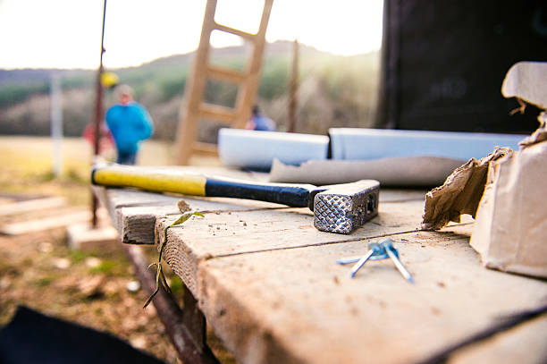 Close up of hammer with nails on wooden boards outside on construction site