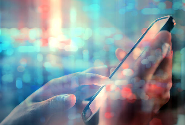 istock using cell phone in city night double exposure 604039240