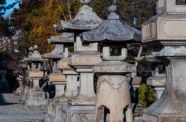 Nagano, Japan - March 6, 2015: A line of stone lanterns at the historic Buddhist Zenko-ji temple
