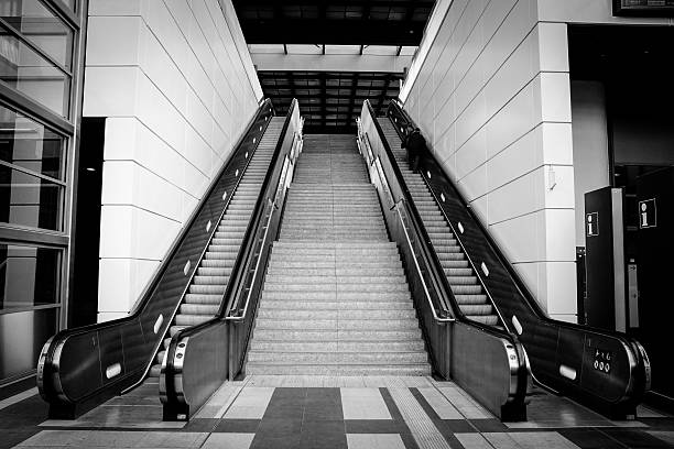 marches au milieu des escaliers mécaniques à la gare - railroad station escalator staircase steps photos et images de collection