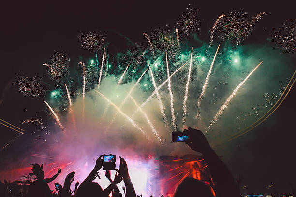 istock Silhouette People Photographing Fireworks Against Sky At Night 604218325
