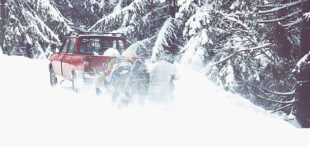 istock Men Sledging Behind Car On Snow Covered Field 604218913