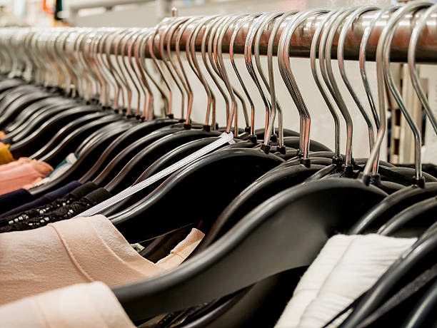 istock Clothes on hangers in clothing store 604334746