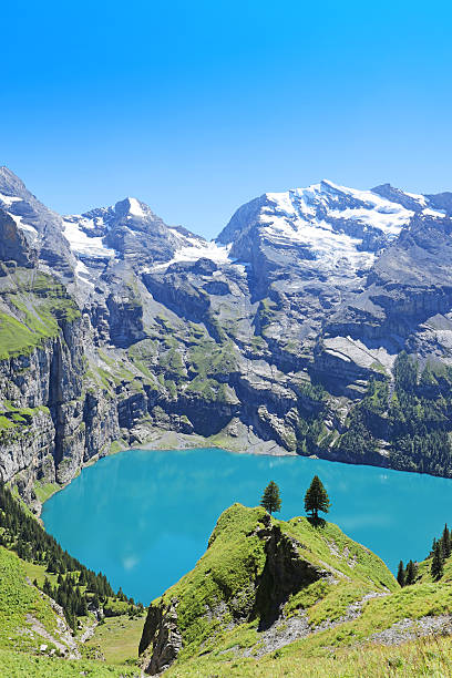 Oeschinensee Switzerland Oeschinensee in Berner Oberland region in central Switzerland. Oeschinen Lake is an amazing hiking destination and a UNESCO World Heritage Site. Vertical image with space for text lake oeschinensee stock pictures, royalty-free photos & images