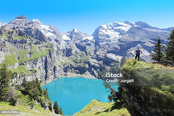 Hiker Admiring Oeschinen Lake In Switzerland Stock Photo - Download Image Now - Lake Oeschinensee, Kandersteg, Summer