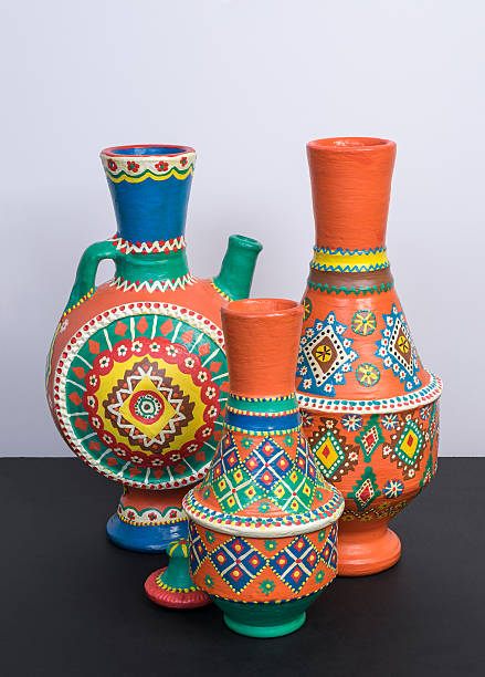istock Orange ornate pottery vases on black table and white wall 604337870