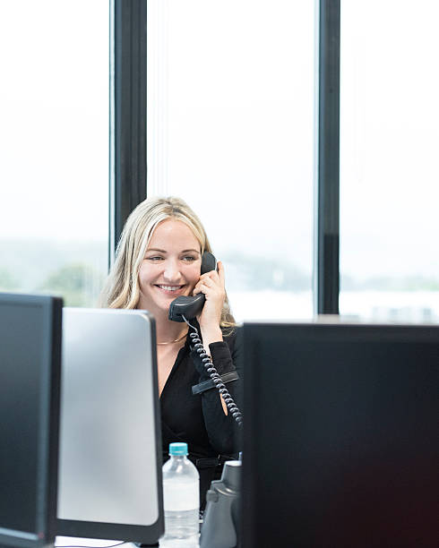 istock Businesswoman at desk in office using telephone, smiling 604340792