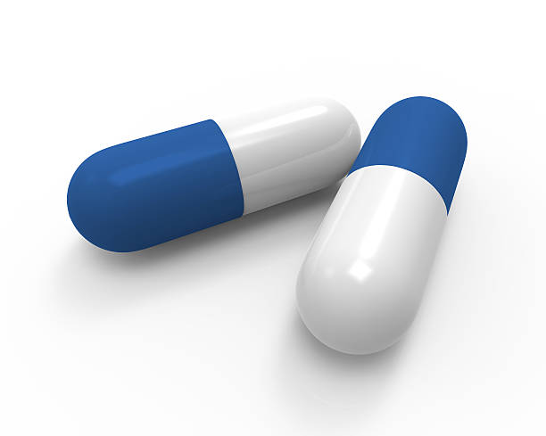 istock 3D close up of two white and blue capsules. 604342756