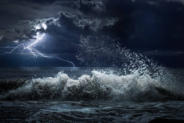 istock dark ocean storm with lgihting and waves at night 604344460