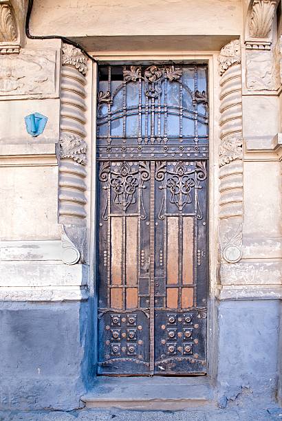 istock Weathered wooden door with forged grill 604344510