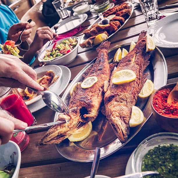 istock Eating Grilled Fish and Fresh Salad in a Restaurant 604344804