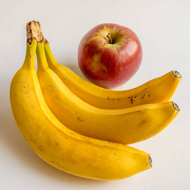 istock ripe bananas and apple isolated on a white background 604345194