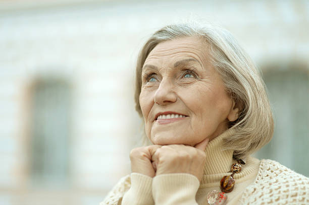 istock senior woman in  autumn park 604345714