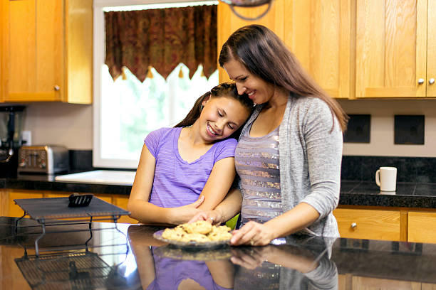 istock Mother and daughter baking cookies 604352932