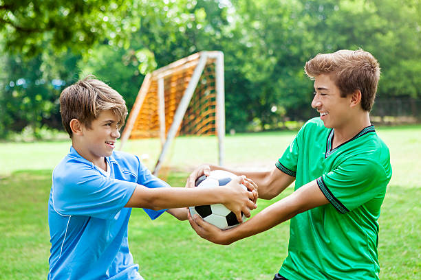 istock Competitive brothers fight over soccer ball 604355472