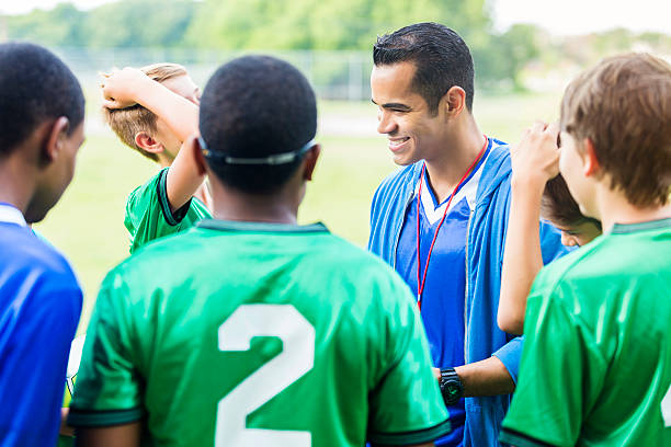 istock Confident soccer coach huddles with players 604355526