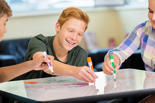 istock Smiling teenager working on animation project in makerspace class 604355552