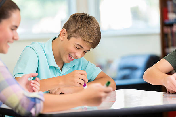 istock Laughing male teenager working at makerspace animation station 604355594