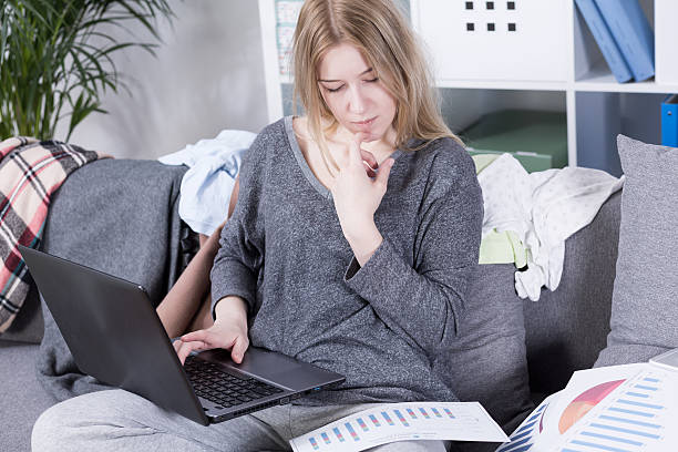 Work from home Young busy businesswoman working at home on a sofa in sweatpants. Checking the business plan jogging pants stock pictures, royalty-free photos & images