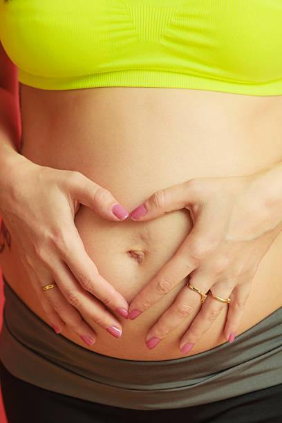 istock pregnant woman making heart shape with hands over belly 604359122