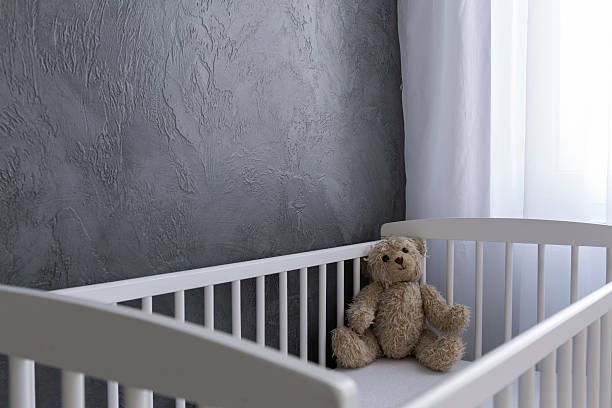 Waiting for the baby Shot of a teddy bear sitting in a crib crib photos stock pictures, royalty-free photos & images