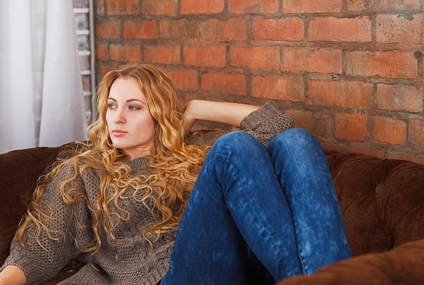 istock Happy young beautiful woman relaxing on sofa at home 604359620