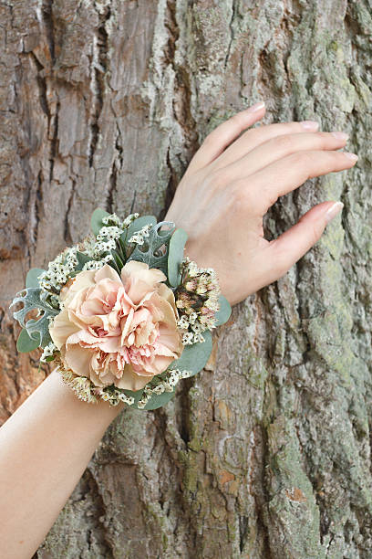 istock Orange and green wrist corsage on a hand 604359968