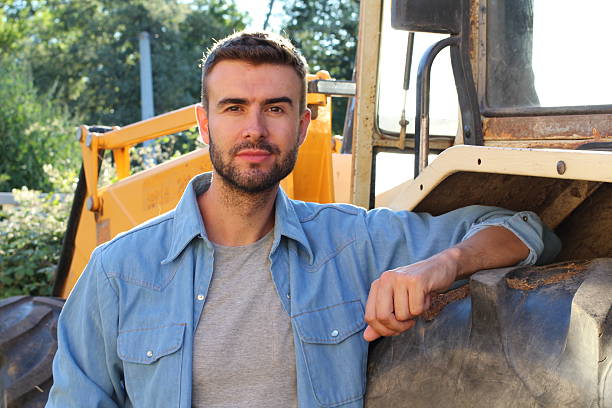 istock Farmer posing in front of his tractor 604364384