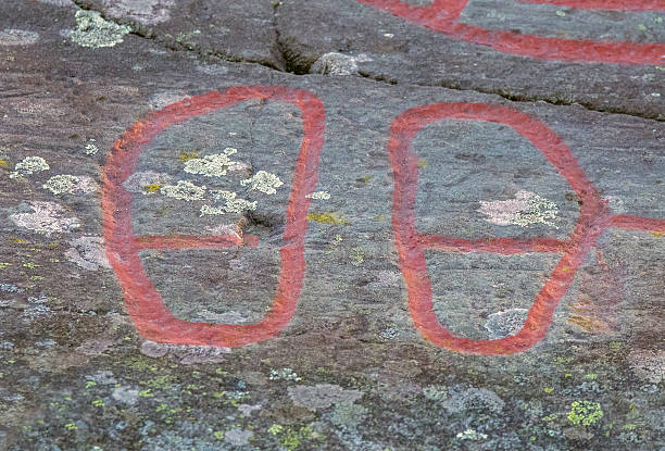 istock Ancient rock carvings that lookes like shoes 604365412