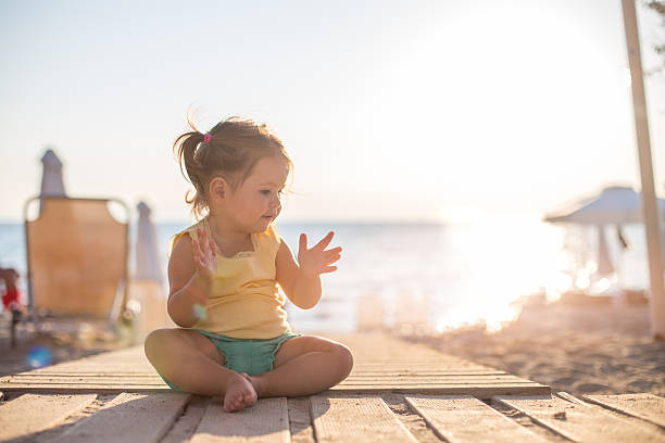 menina sentada em um caminho de madeira em uma praia - beach family boardwalk footpath - fotografias e filmes do acervo