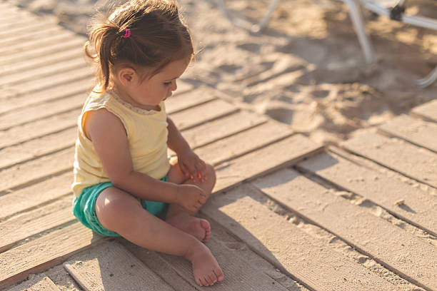 dziewczynka siedząca na drewnianej ścieżce na plaży - beach family boardwalk footpath zdjęcia i obrazy z banku zdjęć