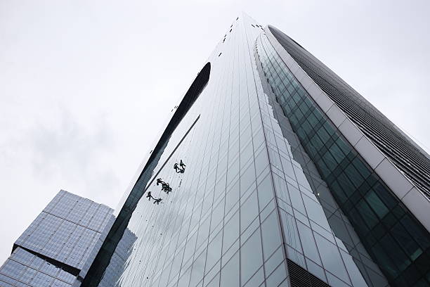 istock group of workers cleaning windows service on high rise building 604367902