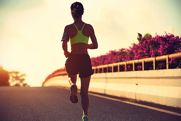 istock young woman runner running on city bridge road 604369714