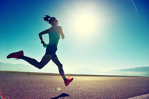 日の出 の海辺のトレイルで走っている若いフィットネスの女性ランナー - 走る ストックフォトと画像