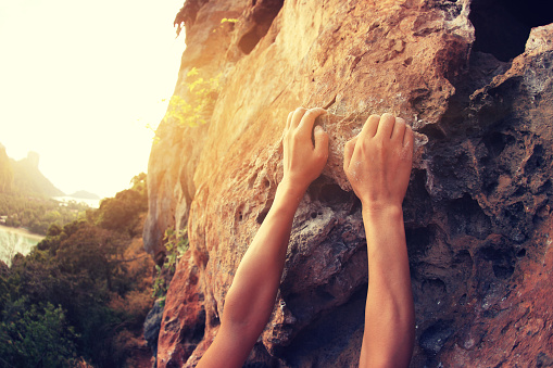 young woman rock climber hands climbing at seaside mountain cliff rock