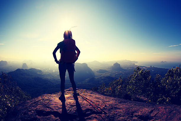 istock young woman backpacker hiking on mountain peak cliff 604371472