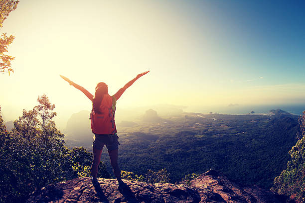 istock successful woman backpacker hiking on sunrise mountain peak cliff 604372486