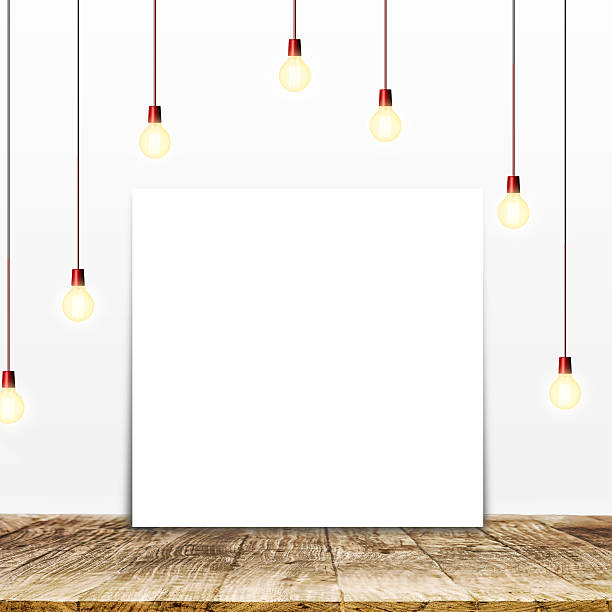 istock Mock up poster paper on wood table with ceiling lamps 604373790