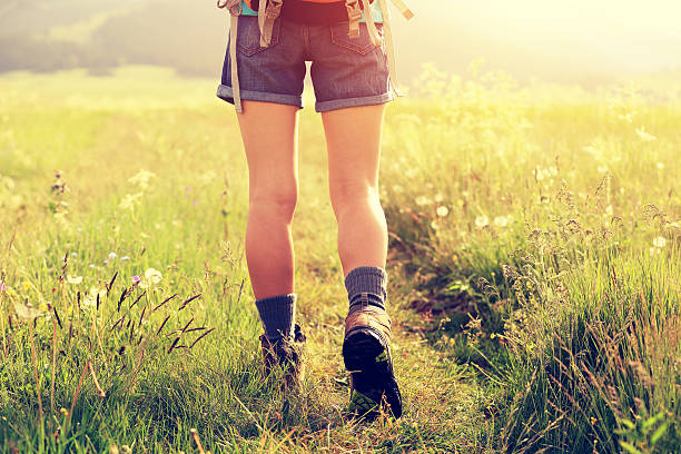istock young woman hiker walking on trail in grassland 604375324
