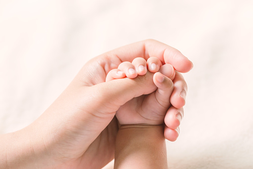 Baby feet in parent's hands. Tiny Newborn Baby's feet in parent's hands.