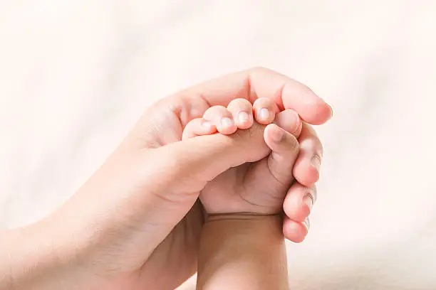 Photo of Baby hand holding finger mom on vintage tone. (Selected focus)