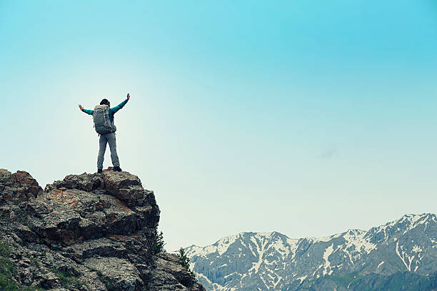 istock cheering successful woman backpacker open arms on mountain peak 604375800