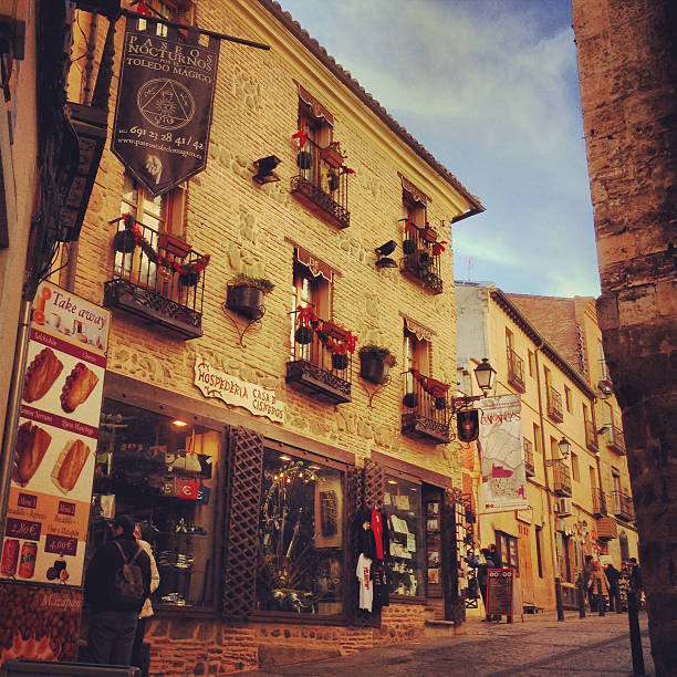 Toledo, Spain - December 23, 2013: Toledo streets with shops and people, Spain. Fast food restaurants and gifts shops. 