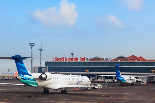 Denpasar, Bali Island, Indonesia - August 31, 2016: Aircrafts of national Indonesian air carrier Garuda in front of passenger terminal of Denpasar International Airport Ngurah Rai.