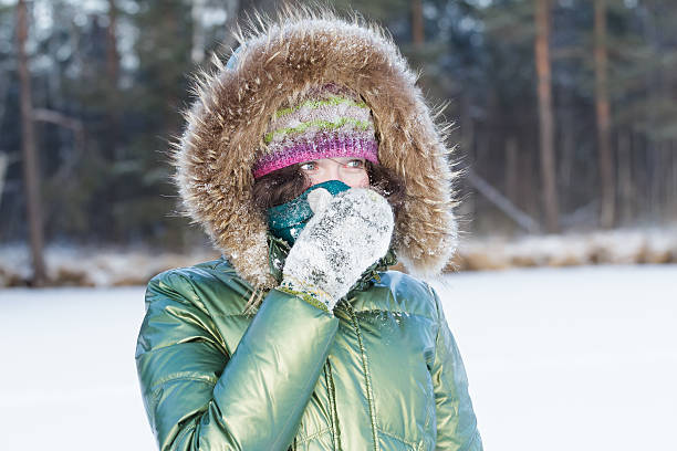 istock Young woman in winter forest during cold weather hiding face 604380876