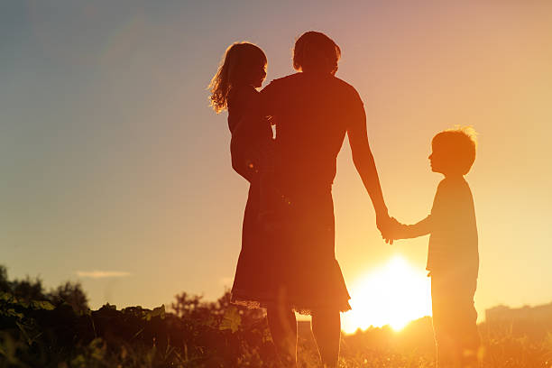 istock mother and two kids walking on sunset 604382668