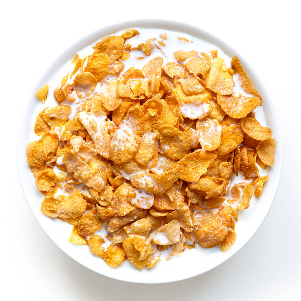 Bowl of cornflakes in milk isolated on white from above. Bowl of cornflakes in milk isolated on white from above. breakfast cereal photos stock pictures, royalty-free photos & images