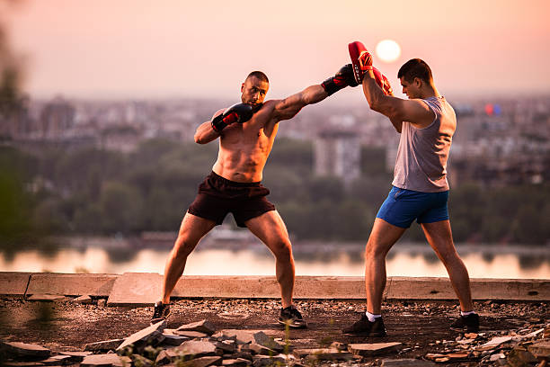 Tough boxers practicing together at sunset.