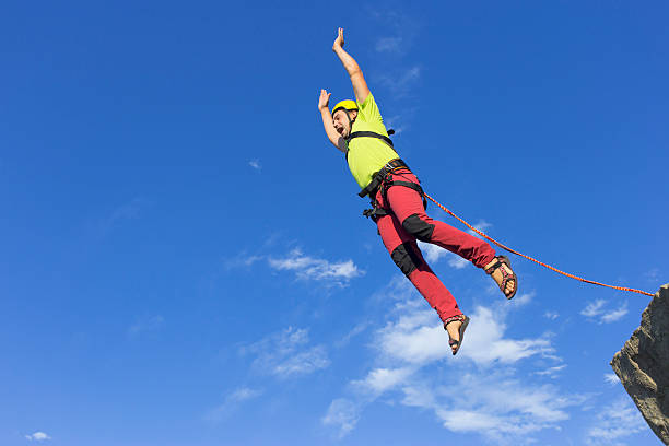 istock Jump rope from a high rock in the mountains. 604786338