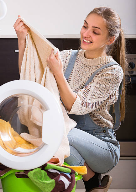 istock Girl doing laundry at home 604796144